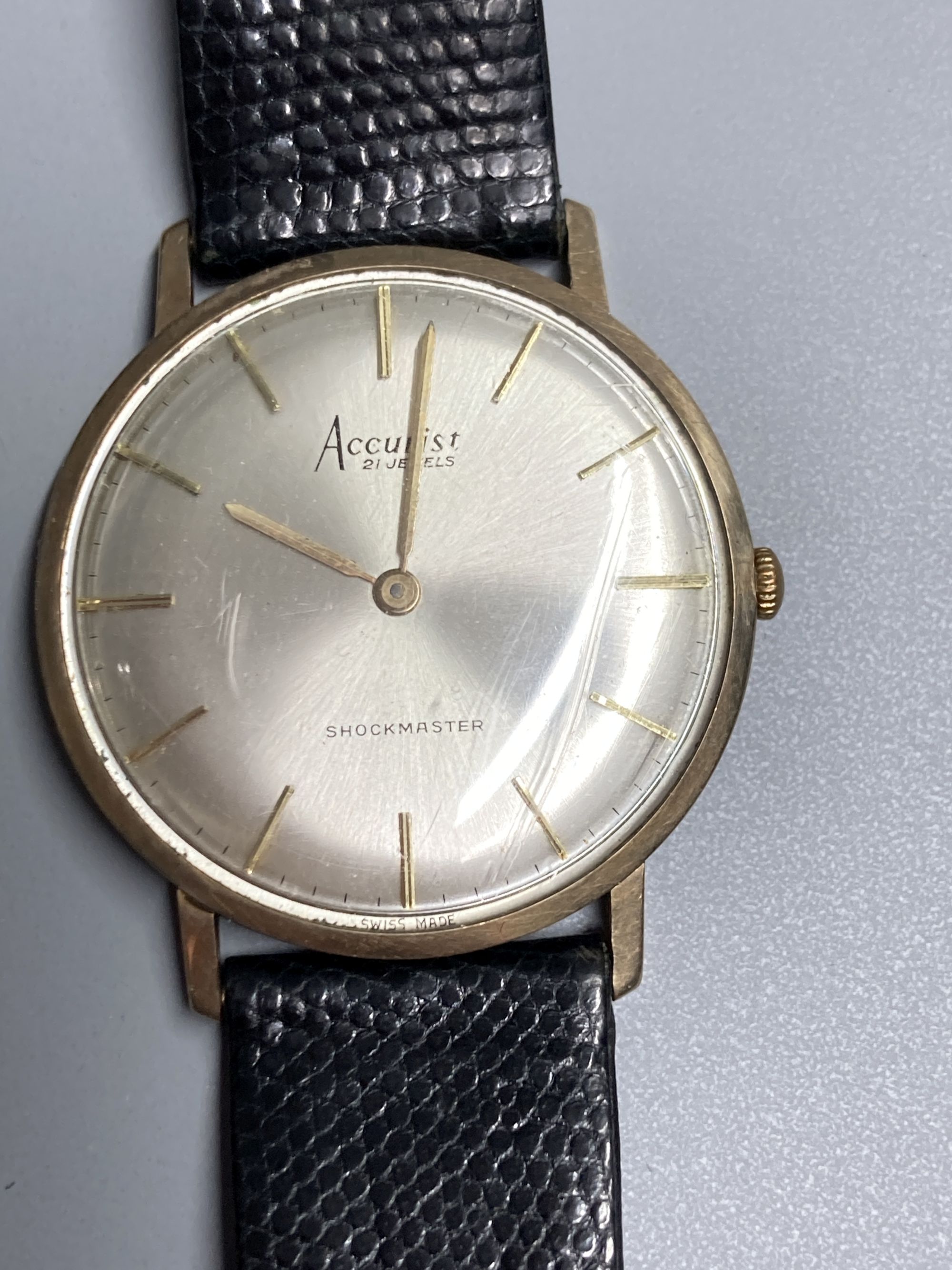 A gentlemans 9ct gold Accurist shockmaster manual wind wrist watch, on associated strap, gross 21.5 grams,